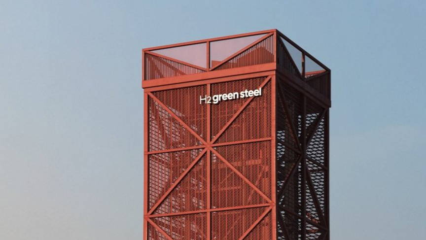 top of a bigg red building with the H2 green steel logo on and blue sky 