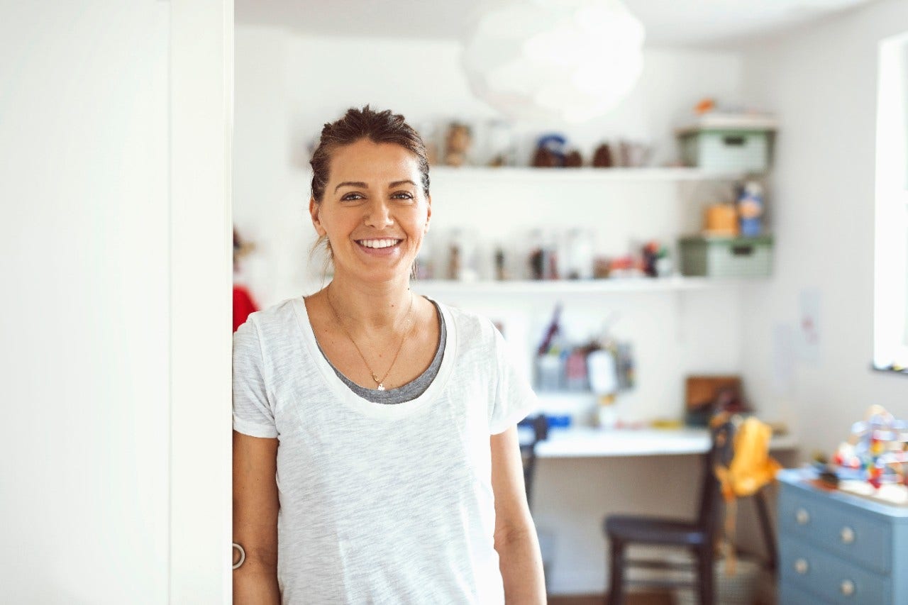 Confident - smiling woman leaning shoulder against wall