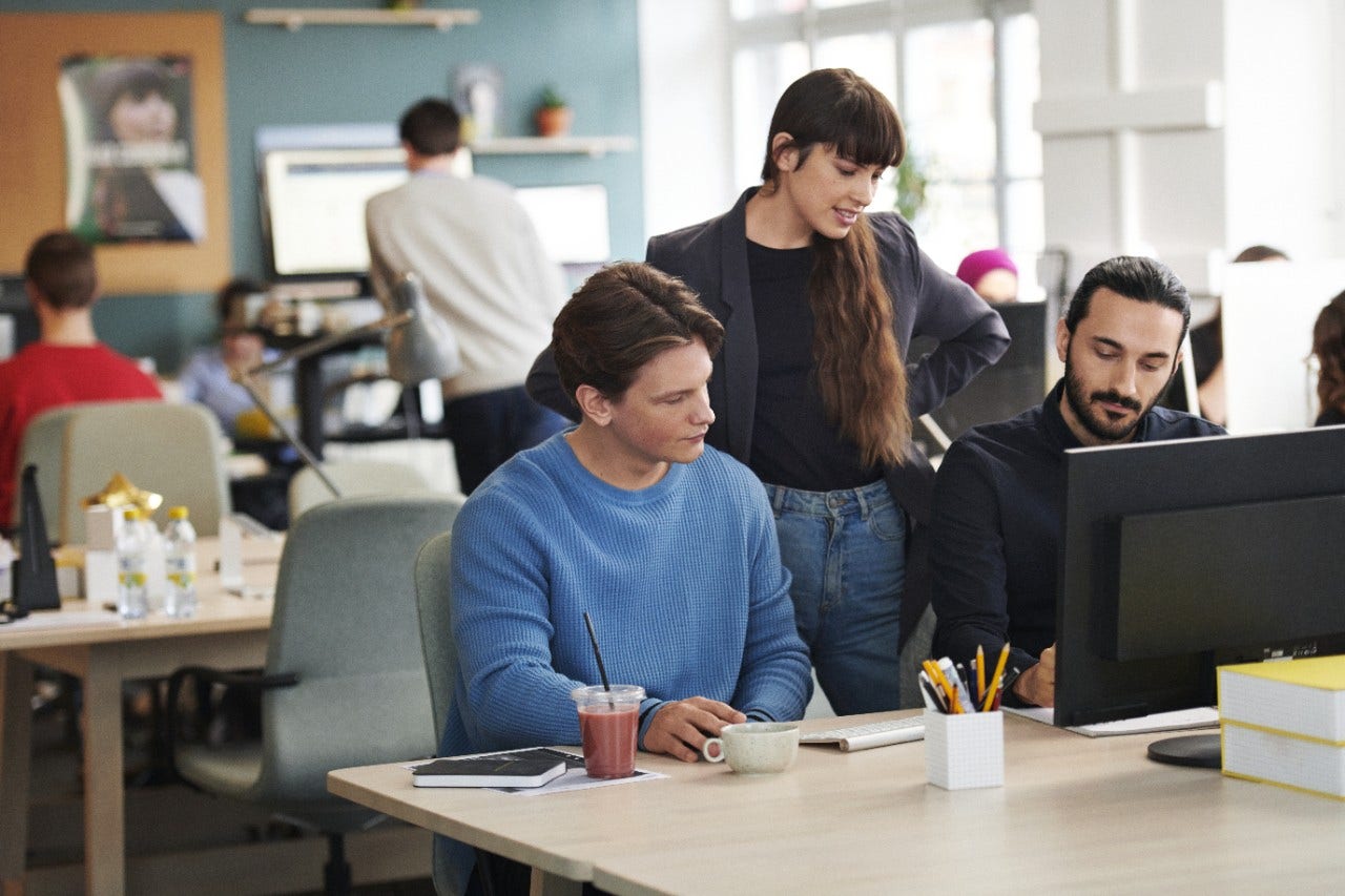 Three work colleagues in front of a computer screen